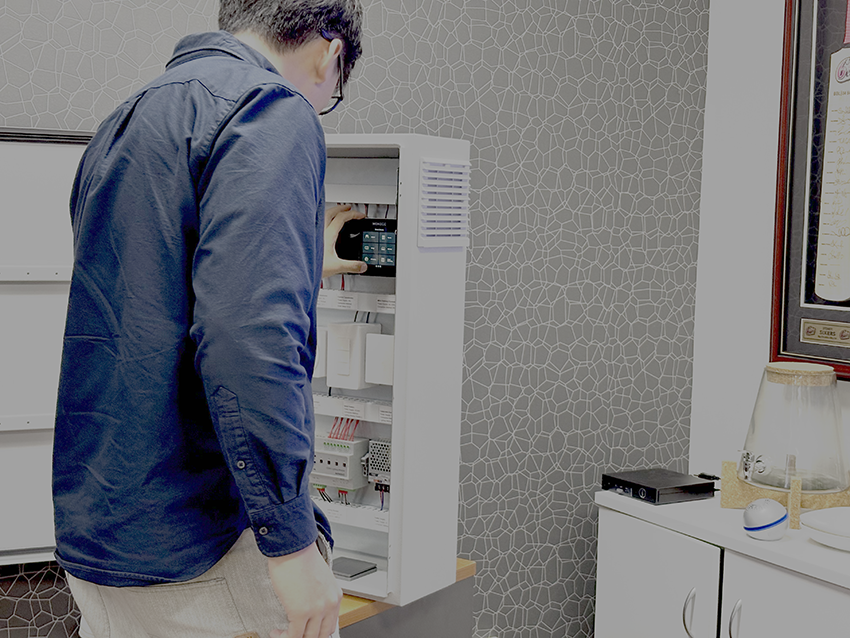 Bovara representative inspecting Monecc energy monitoring display enclosure.