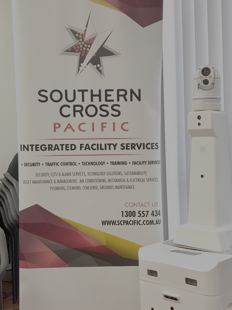 First generation autonomous security robot displayed beside Southern Cross Pacific branding.