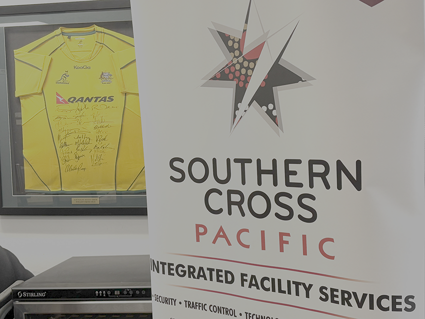 Southern Cross Pacific banner displayed beside framed signed Wallabies rugby jersey.